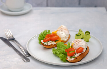 Poached egg toast with tomato and cream cheese and bread on a plate. Healthy food concept.