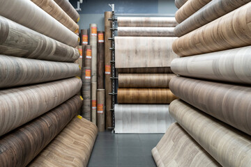 Rolls of new linoleum on the window of a hardware store. A large selection of linoleum
