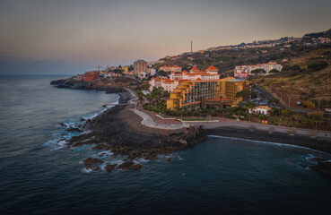 Coastline of Canico de Baixo and hotels at sunrise. Madeira, october 2021. Aerial drone picture