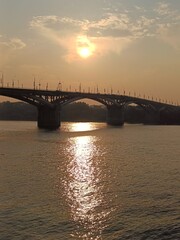 Fototapeta premium Nizhny Novgorod bridge at sunset. Rapid transit, road bridge, metro metromost over OKA river. Beautiful sunset over cityscape.