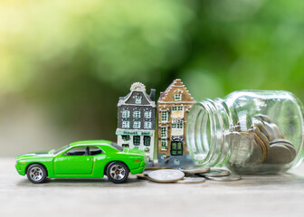 Stack of coins, toy house and car on table, saving for future