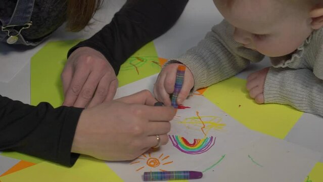 Woman and her daughter concentrated on painting process 