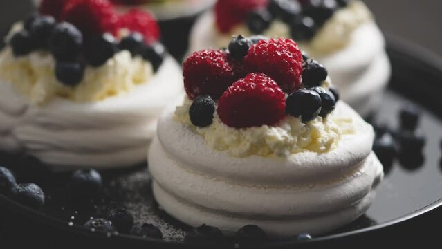 Delicious mini pavlova meringue desserts served with frozen frosty berries