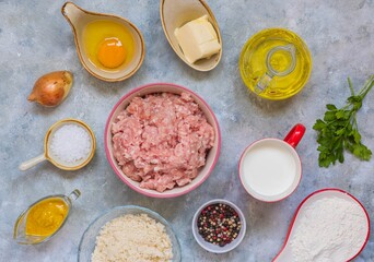 Prepared ingredients for cooking meatballs on a gray concrete background. Step by step recipes.