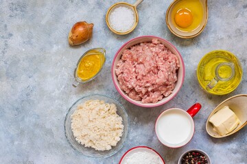 Prepared ingredients for cooking meatballs on a gray concrete background. Step by step recipes.