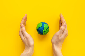 Modeling clay world in hands. Earth Day concept