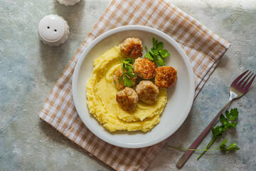 Meatballs with mashed potatoes on a gray plate on a gray concrete background. Recipes for main dishes.