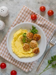 Meatballs with mashed potatoes on a gray plate on a gray concrete background. Recipes for main dishes.