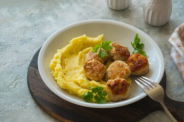 Meatballs with mashed potatoes on a gray plate on a gray concrete background. Recipes for main dishes.