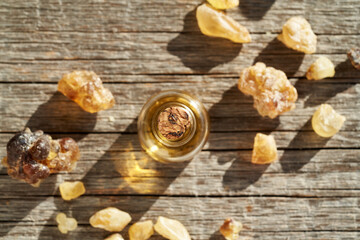 A bottle of frankincense essential oil with frankincense resin crystals