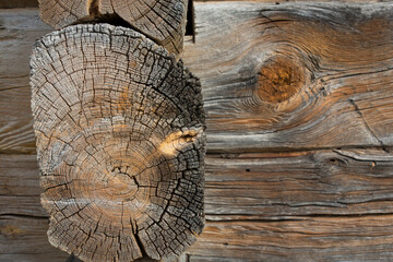 Wooden logs of an old house. Close-up. Weathered gray wood texture. Background.