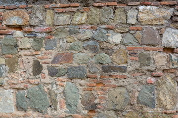 Combined wall of an ancient castle, part of a medieval castle wall made of stone