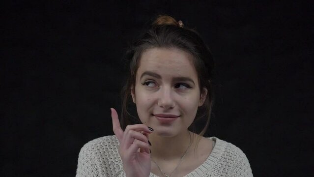 Slow Motion girl thinking and looking up over black background