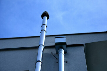 industrial white building with sheet metal facade of repeating rectangle paneling. on wall are two...