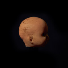 Damaged Dirty Doll head on black background