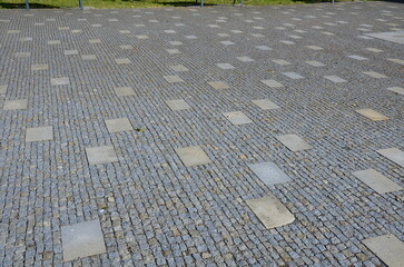 granite cobblestone tiles in a large area and inside cut irregularly placed cut stone slabs, stone...