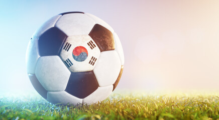 Football soccer ball with flag of South Korea on grass