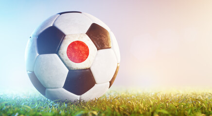 Football soccer ball with flag of Japan on grass