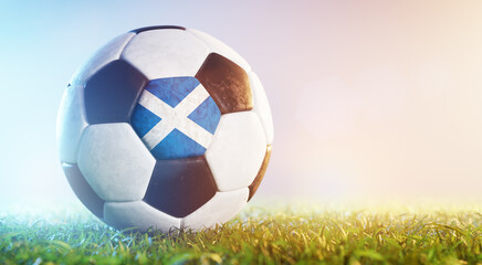 Fototapeta premium Football soccer ball with flag of Scotland on grass