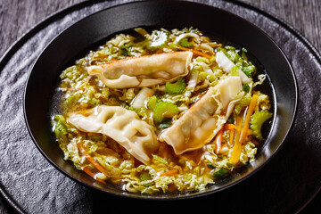 Asian Gyoza Soup in black bowl, top view