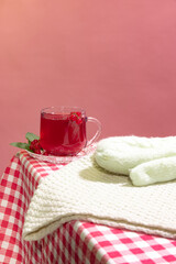 Obraz na płótnie Canvas Teacup of delicious berry tea with raspberry, mint and cinnamon stick isolated over orange background. Winter drink