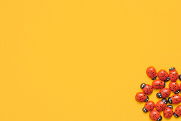 Colored wooden figures in the form of ladybugs on a yellow background