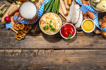 Oktoberfest holiday greeting card, menu, invitation background, Traditional Oktoberfest festival food, bavarian sausages, pretzels, potato, sauerkraut, beer mug on wooden background, copy space above