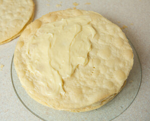 Making homemade Napoleon cake. The cakes are smeared with cream