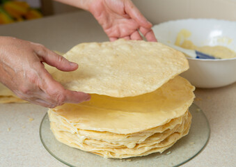 Making homemade Napoleon cake. After spreading the cream on the previous cake, put another one
