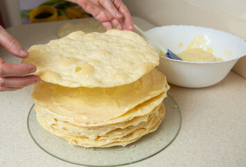 Making homemade Napoleon cake. After spreading the cream on the previous cake, put another one