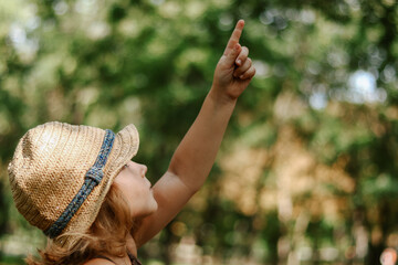 Girl in a straw hat outdoors. Portrait of a cute girl 5 years old. The child is sitting in the...