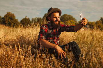 Male traveler taking selfie in field