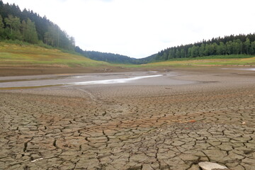 A dried up empty reservoir and dam during a summer heatwave, low rainfall and drought in Saxony,...
