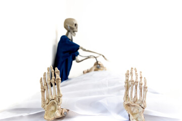 View from patients feet, skeleton doctor wearing blue scrubs uses stethoscope to examine patient...
