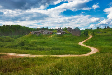 Fototapeta na wymiar Beautiful village on a hill with wooden houses in the Arkhangelsk region in summer in Russia.