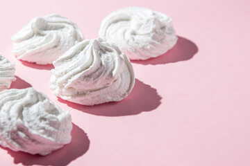 White marshmallows on a pink background. Light and sweet dessert.