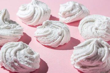 White marshmallows on a pink background. Light and sweet dessert.