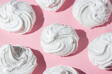 White marshmallows on a pink background. Light and sweet dessert.