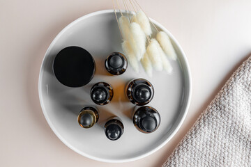 Top view of serum bottles on ceramic tray. Sustainable lifestyle concept, natural cosmetics. Unbranded Cosmetic product presentation. copy space
