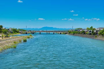 Tuinposter 京都　青空に映える美しい宇治川　コピースペースあり（京都府宇治市）Kyoto Beautiful Uji River shining against the blue sky with copy space (Uji City, Kyoto Prefecture, Japan) © Manuela