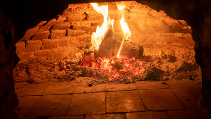 Wood fired oven. Flares of fire rising in the oven. Traditional style wood fired oven.