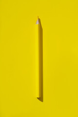 Minimal style composition made of wooden pencil on yellow background. Top view. Flat lay. Back to school concept.