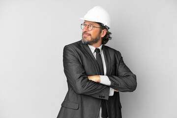 Young architect man with helmet over isolated background with arms crossed and happy