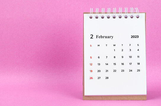 The February 2023 desk calendar on pink color background.