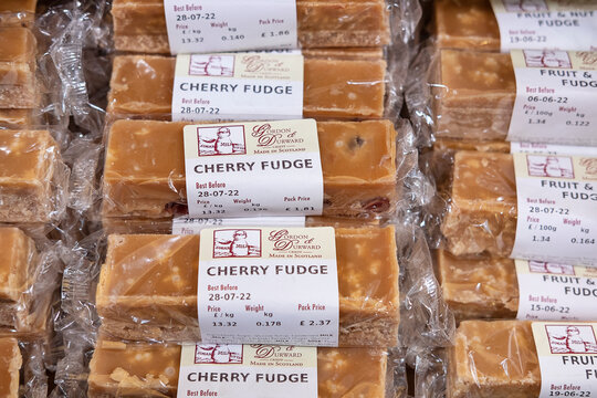 Edinburgh, Scotland, UK - April 13, 2022: delicious Scottish cherry fudge produced by manufacturer and supplier Gordon and Durward and packed in transparent foil stacked in large piles in a candy shop