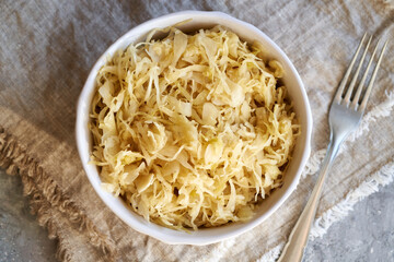 Fermented cabbage or sauerkraut in a bowl with a fork