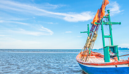 A view of a fishing boat moored by the sea in the morning with a beautiful blue sea and sky.