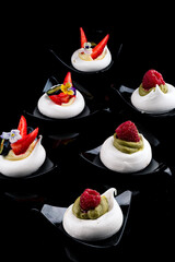 Meringue dessert garnished with forest fruits and strawberries. Meringue is a type of foam cookie made from egg whites and powdered sugar