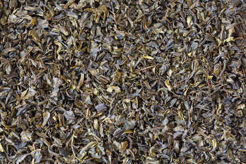 A scattering of Koporsky tea hand-picked and properly hand-twisted. Ivan tea dried leaves, Chamerion angustifolium, top view, close up.