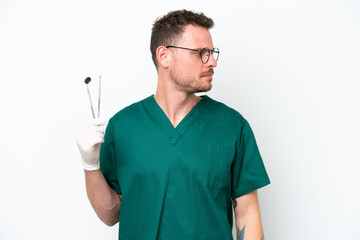 Young caucasian dentist man isolated on white background looking to the side